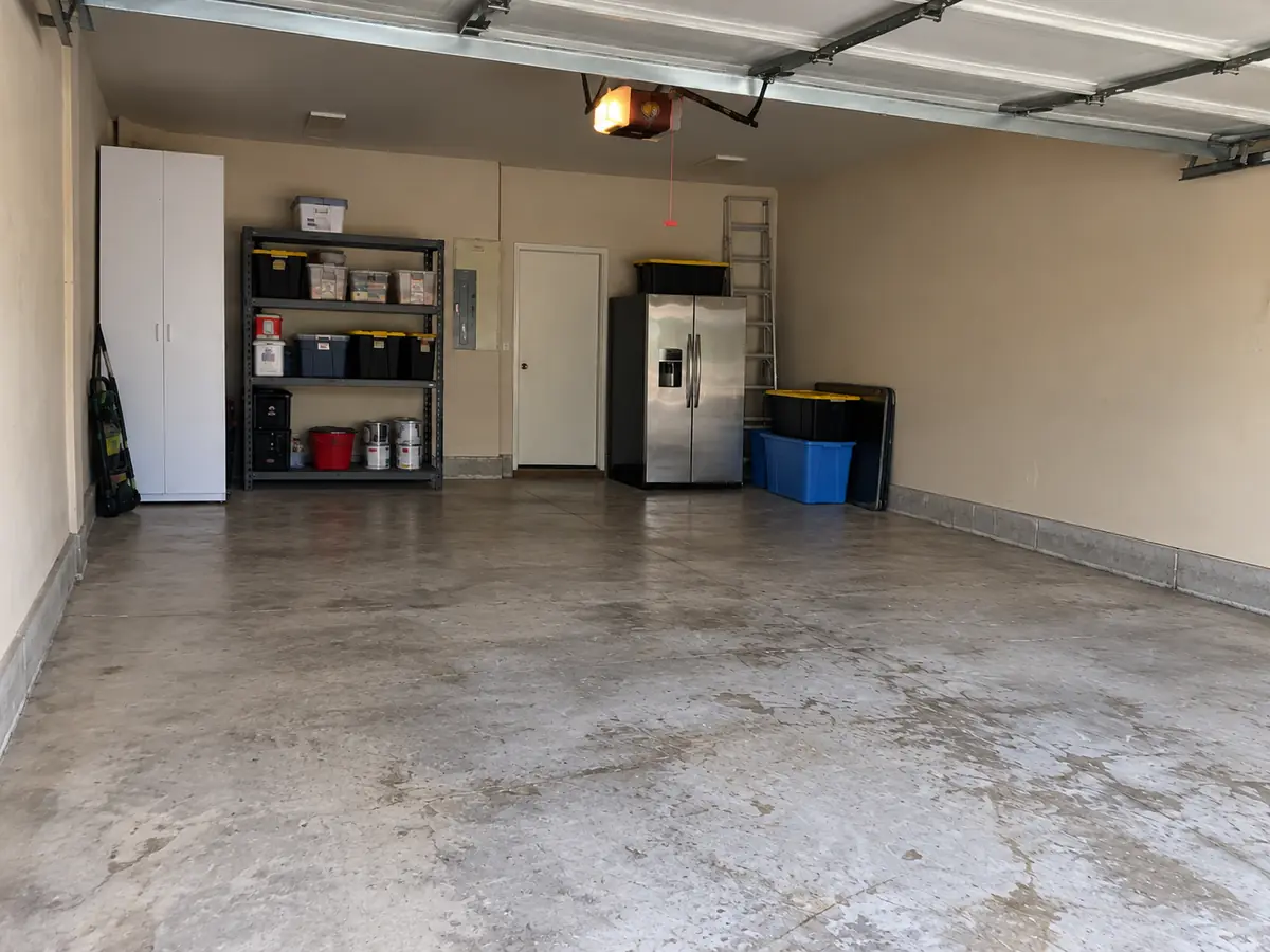 After: the same garage cleared and swept, with the shelves and fridge left in place